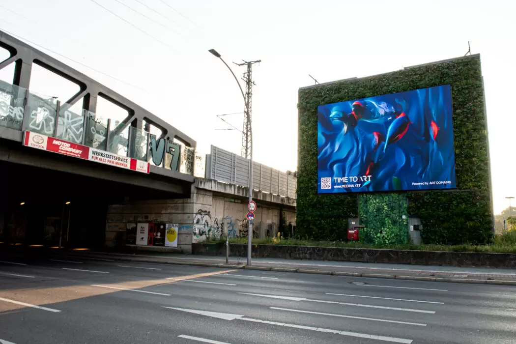 Large digital billboard on a green wall in Berlin showing Medina Kasimova’s TIME TO ART artwork with flowing blue and red forms, part of a citywide public art campaign by .ART and Artcrush.